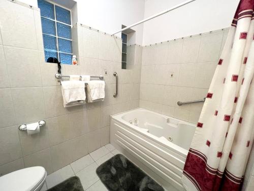 a bathroom with a bath tub and a toilet at Seagaze beach house is perfect for family, a few steps to the beach in Saint James