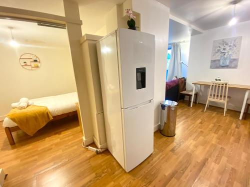 a white refrigerator in a room with a table at Swanky Central Apartment with Free Wifi (Sleeps 4) in Birmingham