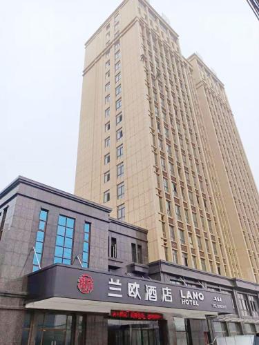 ein hohes Gebäude mit einem Schild davor in der Unterkunft LanOu Hotel Bengbu Huaishang Wanda Plaza Yiwu Trade City in Bengbu