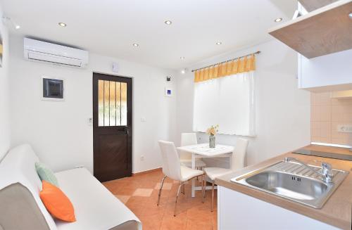 a kitchen and dining room with a sink and a table at Apartment Snjezana 1064 in Rovinj