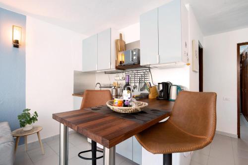 a kitchen with a wooden table and chairs at Casa Vitamin Sea in Caleta De Fuste