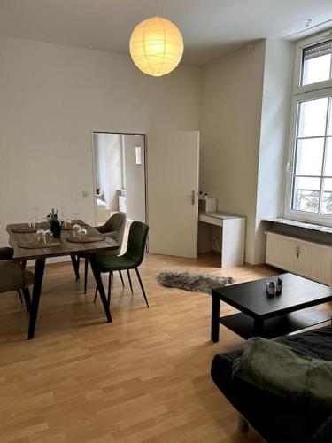 uma sala de estar com mesa e cadeiras e uma sala de jantar em Altstadtflair em Koblenz