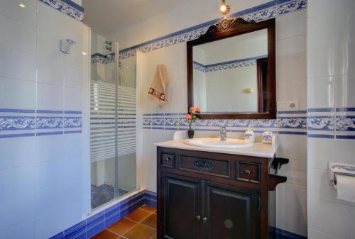 een badkamer met een wastafel, een spiegel en een douche bij Apartamento dúplex centro con garaje gratuito in Ronda