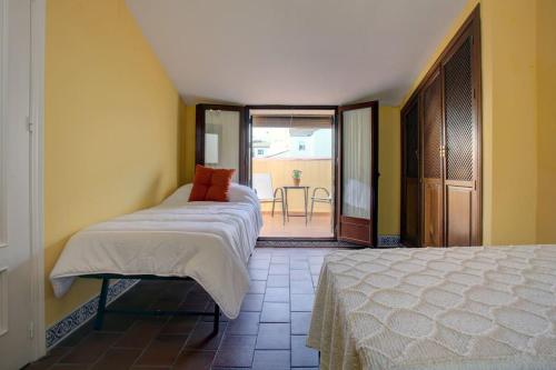 a bedroom with two beds and a view of a patio at Apartamento dúplex centro con garaje gratuito in Ronda