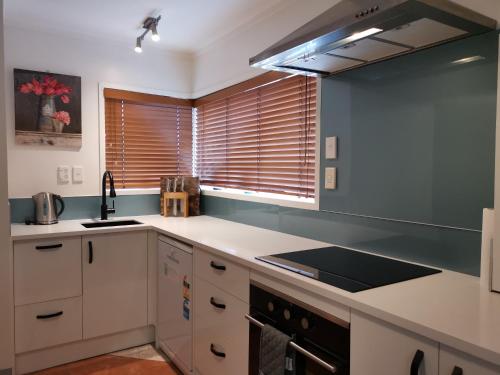 a kitchen with a sink and a stove top oven at Pukaki Holiday Apartments in Rotorua