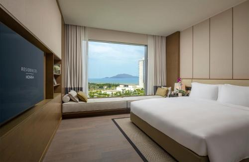 a bedroom with a large bed and a large window at Hoiana Residences in Hoi An