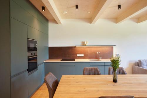 a kitchen with a wooden table with chairs and a counter at Apartmány Lipno Přední Výtoň in Přední Výtoň