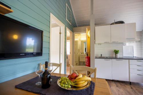 a table with a bowl of fruit and a bottle of wine at Topcamp Mosjøen - Helgeland in Mosjøen