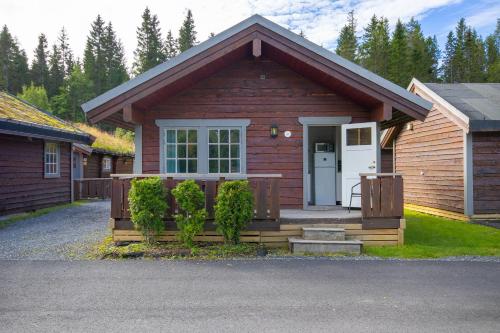 a small wooden house with a white door at Topcamp Mosjøen - Helgeland in Mosjøen