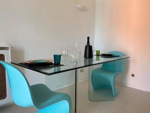 a table and chairs with wine glasses and a bottle at APPARTAMENTO DI CHARME NEL CUORE DI SANREMO in Sanremo