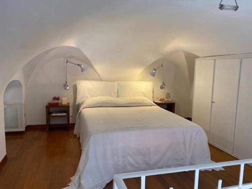 a bedroom with a large white bed in a room at APPARTAMENTO DI CHARME NEL CUORE DI SANREMO in Sanremo