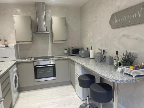 a kitchen with a counter with a stove top oven at Courtyard Holiday Apartments in Belper