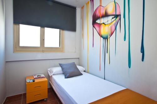a bedroom with two beds and a painting of a heart at Ryans Pocket in Ibiza Town