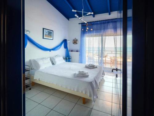 a blue bedroom with a bed and a window at Savas House in Paralía Avdhíron