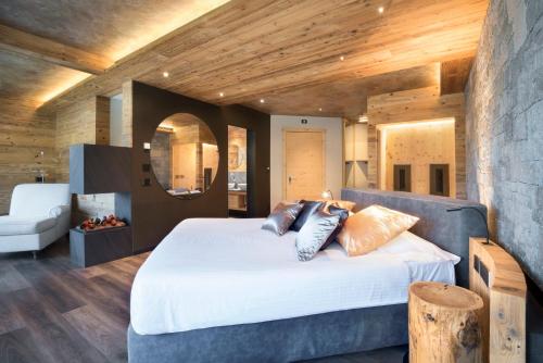 a bedroom with a large white bed and wooden ceilings at Hotel Lac Salin Spa & Mountain Resort in Livigno