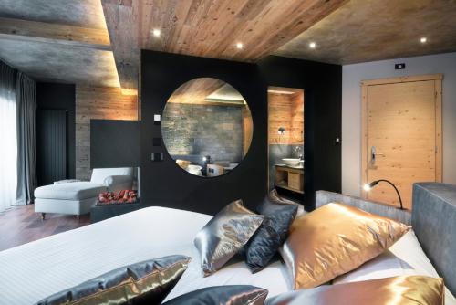 a bedroom with a large bed and a mirror at Hotel Lac Salin Spa & Mountain Resort in Livigno