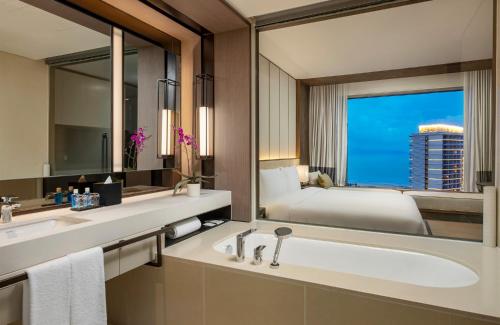 a bathroom with a bed and a sink and a mirror at Hoiana Residences in Hoi An