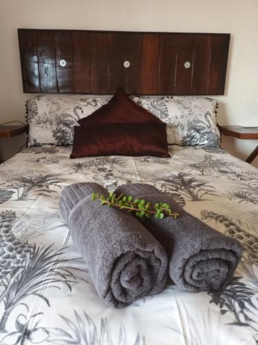 a bed with two towels on top of it at Chameleon Lodge in Cannonvale