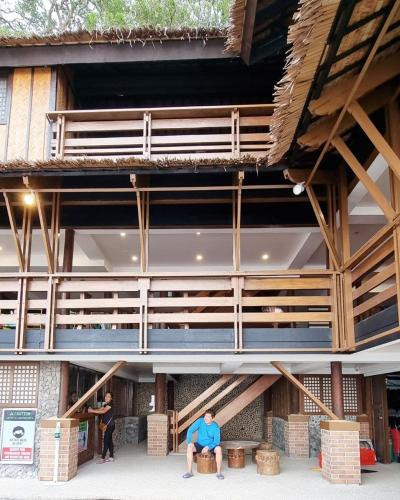 a man sitting on a bench in front of a building at Aquaventure Reef Club in Mabini