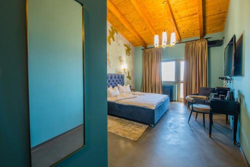 a bedroom with a bed and a desk and a mirror at Pensiunea Casa Buna in Gîrbova