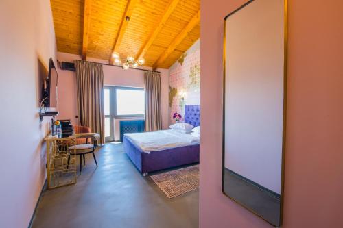 a bedroom with a bed and a table and a mirror at Pensiunea Casa Buna in Gîrbova