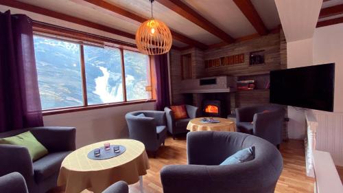 a living room with couches and tables and a television at Storfossen Hostel in Gratangen