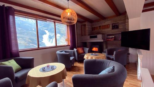 ein Wohnzimmer mit Sofas, Tischen und einem TV in der Unterkunft Storfossen Hostel in Gratangen