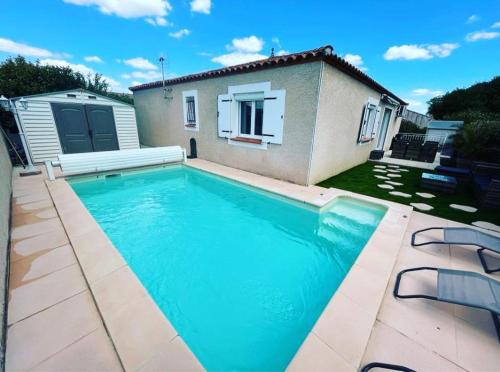 a large swimming pool in front of a house at La Villa de l'Olivier piscine privée et parking in Carcassonne
