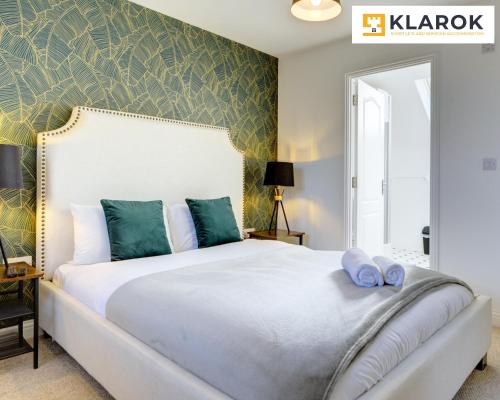Un dormitorio con una gran cama blanca con almohadas azules. en LARGE 4 Bedroom Semi-Detached House Sleeps 7 By Klarok Short Lets & Serviced Accommodation, en Peterborough