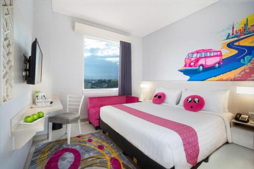 a hotel room with a bed with pink pillows at favehotel Malang in Malang