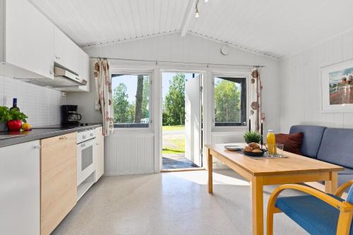 a kitchen and living room with a wooden table and a dining room at Topcamp Bogstad - Oslo in Oslo