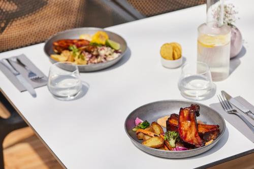 two bowls of food on a table with glasses at ESE HOTEL in Birštonas