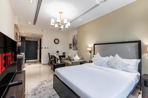 a bedroom with a large bed and a living room at Daniels Studio Elite Downtown Partial Burj Khalifa View in Dubai