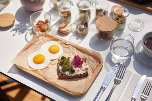 una mesa con un plato de comida con huevos. en ESE HOTEL en Birštonas