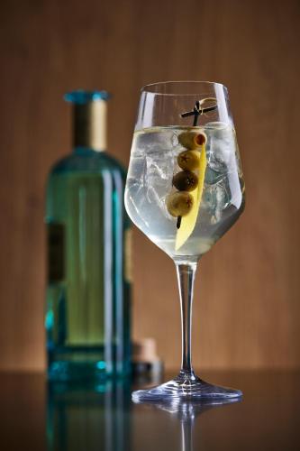 a glass of water with a bottle of wine at ESE HOTEL in Birštonas