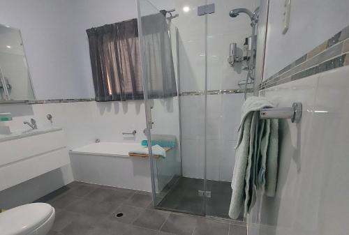 a bathroom with a shower and a toilet and a sink at Cascabelbnb Private 2BR apartment in Noarlunga