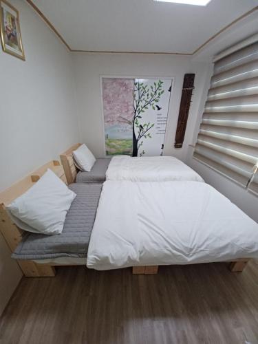 a bedroom with two twin beds and a window at J&J Guesthouse in Jeonju