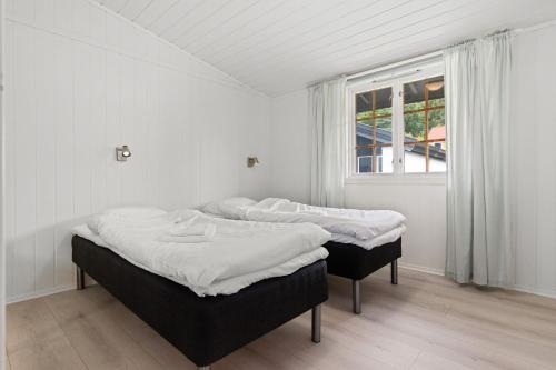 two beds sitting in a room with a window at Topcamp Bogstad - Oslo in Oslo