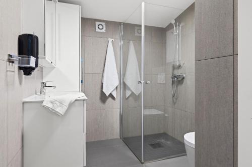 y baño con ducha de cristal y aseo. en Topcamp Bogstad - Oslo, en Oslo