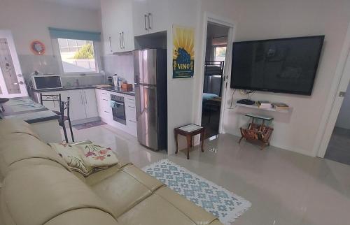 a living room with a couch and a kitchen at Cascabelbnb Private 2BR apartment in Noarlunga