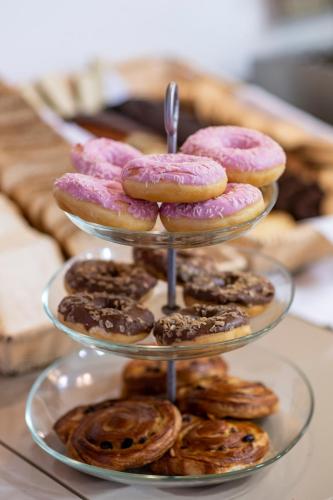 eine dreistöckige Auslage mit Donuts und Gebäck in der Unterkunft Peridis Family Resort in Kos-Stadt