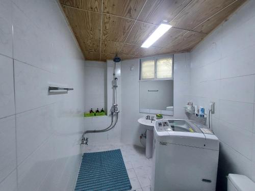 a white bathroom with a sink and a toilet at J&J Guesthouse in Jeonju