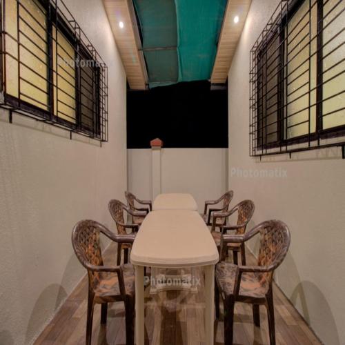 a meeting room with a white table and chairs at Hotel Snehaprabha - Near to Nagaon Beach Alibaug in Alibaug