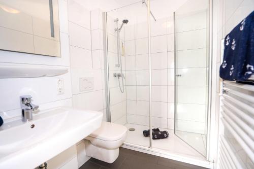 uma casa de banho com um chuveiro, um WC e um lavatório. em Hanseat II Whg 147 em Grömitz