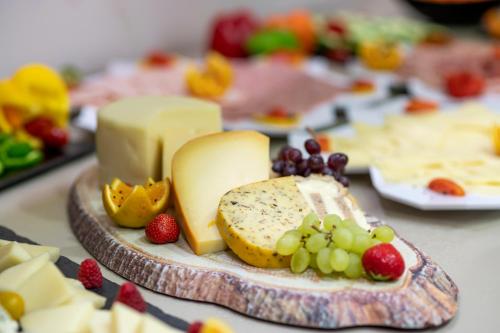 einen Teller mit Käse und Obst auf dem Tisch in der Unterkunft Peridis Family Resort in Kos-Stadt