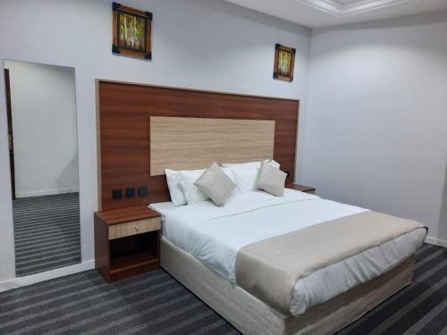 Al Qunfudhahにあるجوهرة القنفذةのベッドルーム1室(大型ベッド1台、木製ヘッドボード付)