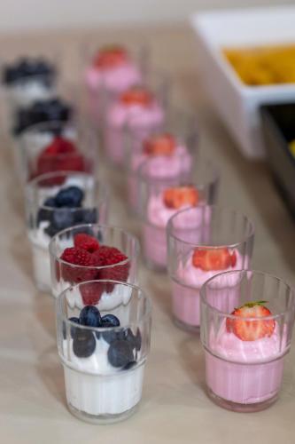 eine Reihe von Bechern gefüllt mit Obst und Joghurt in der Unterkunft Peridis Family Resort in Kos-Stadt