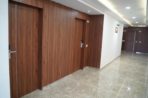 a hallway with wooden doors in a building at LEELA BIZOTEL in Junagadh