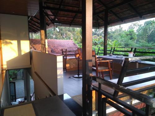 a balcony of a house with a table and chairs at Kalappura Homestay in Alleppey