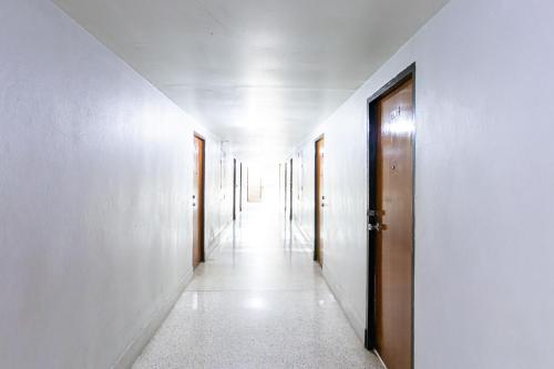 a hallway with white walls and wooden doors at Boonchai Mansion in Hat Yai
